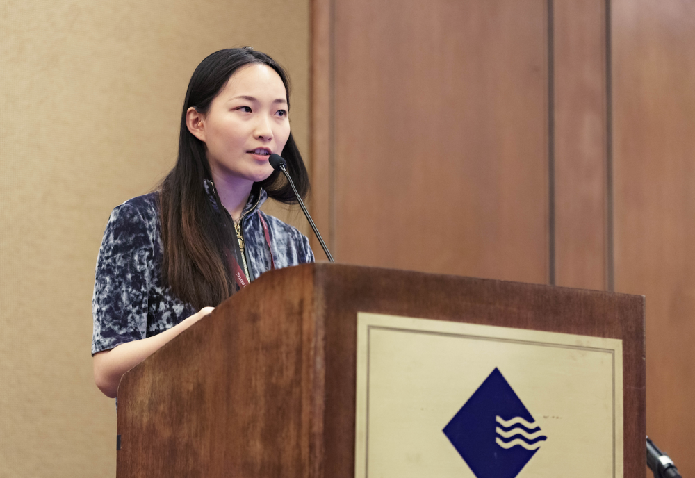 Helena Song speaking at a podium