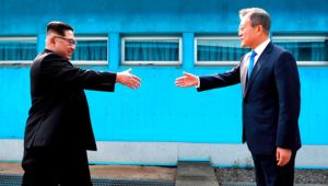 North Korean leader Kim Jong Un, left, prepares to shake hands with South Korean President Moon Jae-in over the military demarcation line at the border village of Panmunjom in the Demilitarized Zone on April 27, 2018.