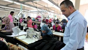 In this Wednesday, May 20, 2015 photo, manager Maher Howeidi inspects production at a garment factory in the village of Kitteh in northern Jordan where dozens of Jordanian women sew jeans for the U.S. market.