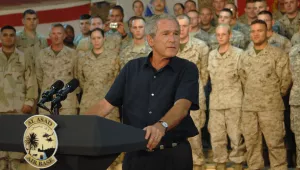 President George W. Bush thanks U.S. troops in Al Asad, Iraq, Sept. 3, 2007. He stands at a podium in front of rows of troops in uniform.