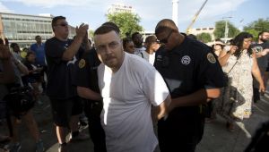 A man is arrested as the statue of Confederate General Robert E. Lee is removed in New Orleans