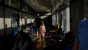 Ukrainian refugees wait in a bus stop near the border after arriving in Tijuana, Mexico