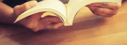Person holding open book.