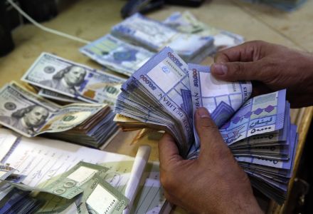 A man counts Lebanese pounds at an exchange shop, in Beirut, Lebanon. (AP Photo/Hussein Malla)