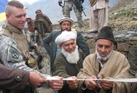 FORWARD OPERATING BASE MEHTAR LAM, Afghanistan—Air Force Lt. Col. Brad Bredenkamp holds the ribbon as Mohammad Qasim, Alishang District Administrator, cuts it to celebrate the completion of a new flood protection wall in Laghman Province’s Dumlam Village 