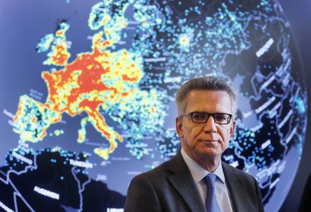 German Interior Minister Thomas de Maiziere talks to the media during his visit to the central department of fighting internet criminality (ZIT) in Giessen, Germany, Wednesday, Feb. 8, 2017. In background a map showing the amount of cyber attacks in a30 days.