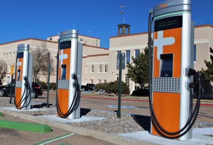 three orange electric vehicle charging stations