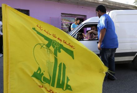 Hezbollah supporters distribute sweets to passersby, as they celebrate the fall of the Syrian town of Qusair to forces loyal to President Bashar Assad and Hezbollah fighters, in Bazzalieh village, Lebanon, near the Lebanese-Syrian border, Wednesday, June 5, 2013.