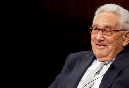 Henry Kissinger against a black background