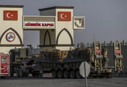 A Turkish forces truck transporting armored personnel carriers, crosses the border with Syria