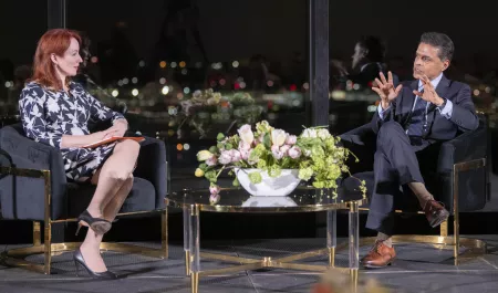 Meghan L O'Sullivan and Fareed Zakaria on stage at the State Room with the lights of Boston in the background.