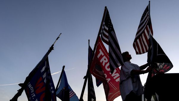 Nikki Fuller, 56, sets up flags on her truck near the Mar-a-Lago estate of President-elect Donald Trump, Monday, Nov. 11, 2024, in Palm Beach, Fla. (AP Photo/Julia Demaree Nikhinson)